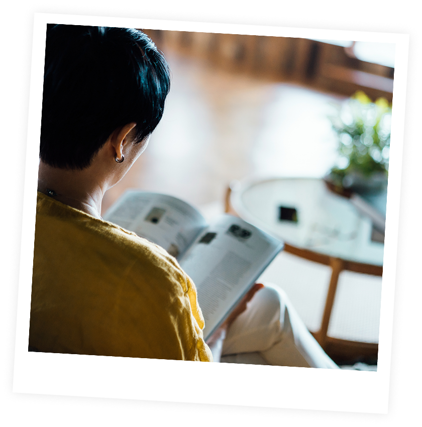 Person reading a magazine in cozy setting.